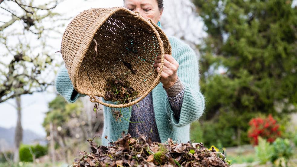 woman composting garden in winter